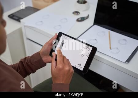 Close up of female artist using pen tablet creating new jewelry designs, copy space Stock Photo