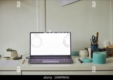 Close up of open laptop with jewelry designs at screen in minimal studio interior, copy space Stock Photo
