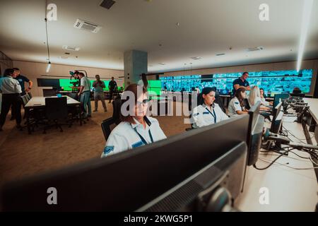 Group of female security operators working in a data system control room Technical Operators Working at workstation with multiple displays, security Stock Photo