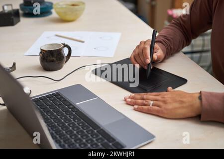 Closeup of unrecognizable black woman working on new designs in studio and using pen tablet Stock Photo
