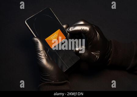 Smishing alert. A cybercriminal sending fraudulent text messages via cell phone to scam vulnerable people. Smishing danger Stock Photo