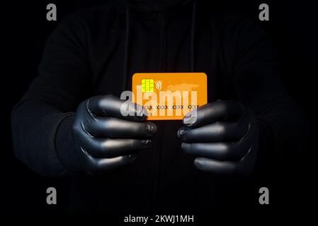 A cybercriminal showing the credit card he has just stolen online. Vulnerability of personal data. Scams on the net. Phishing alert Stock Photo