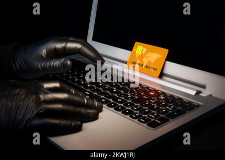 A cybercriminal using a laptop to scam online. Credit card and personal data theft on the net. Danger of phishing Stock Photo