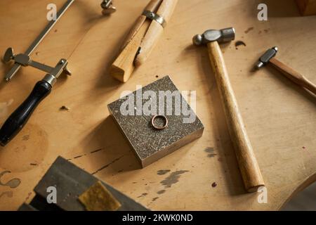 Closeup background image of rustic jewelers workstation with tools and ring on wooden table, copy space Stock Photo