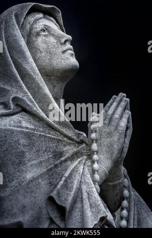 Faithfull Virgin Mary with praying hands and blessing, looking at the sky Stock Photo