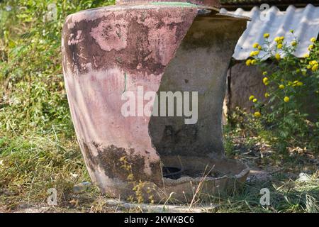 A large traditional damaged water jar on na farm in rural Thailand. Stock Photo