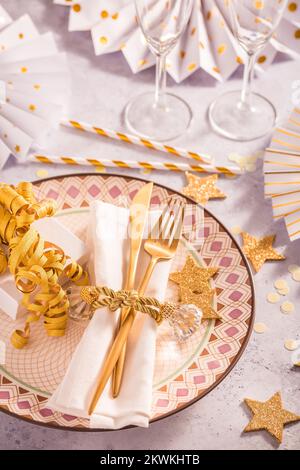 Festive place setting for Christmas and New Year with paper  fans in golden tone Stock Photo