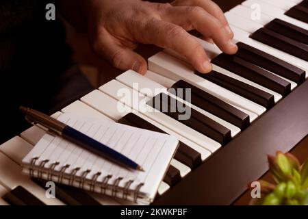 Man composing music on a midi keyboard Stock Photo