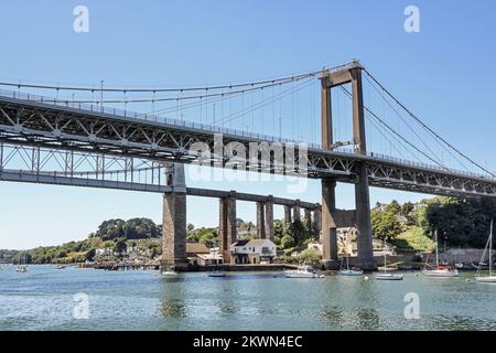 The Saltash side of the Tamar Road Bridge, seen from the middle of the River Tamar. Behind a glimpse of Isambard Kingdom Brunel’s railway bridge and b Stock Photo