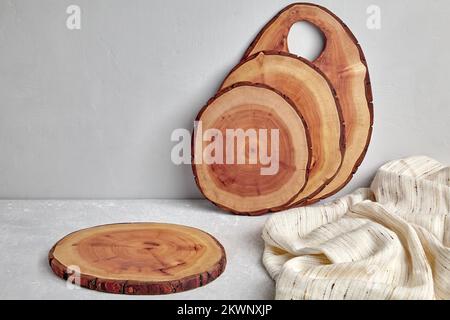 Kitchen space with wooden cutting boards and tea towel on a light concrete table for food presentation Stock Photo