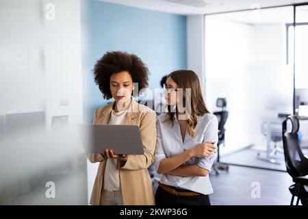 Happy smiling business women working together online on a laptop in office Stock Photo