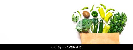 Eco friendly paper shop bag with raw organic green vegetables isolated on white background Flat lay, top view Zero waste, plastic free concept Healthy Stock Photo