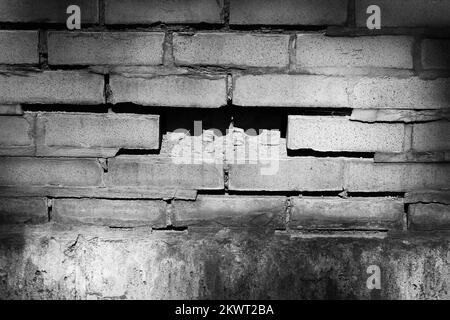 Typical common brick wall with a missing piece in a black and white monochrome. Stock Photo