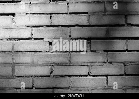 Weathered and worn but typical and common brick wall in a black and white monochrome. Stock Photo