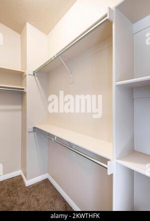 Empty walk in closet of a new home with shelves and metal rods for