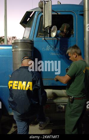 Hurricane Wilma,  West Palm Beach, FL, October 29, 2005  Representatives from the US Forestry and FEMA get trucker information at a fueling station set up at the Florida State Fairgrounds where trucks with water and ice supplied by FEMA go to distribution centers and other staging locations impacted by Hurricane Wilma.. Photographs Relating to Disasters and Emergency Management Programs, Activities, and Officials Stock Photo