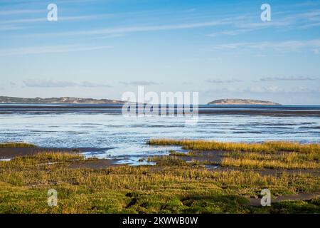View across the seashore and Menai Strait to the Isle of Anglesey and Puffin Island from the coastal path.  Abergwyngregyn, Gwynedd, north Wales, UK Stock Photo