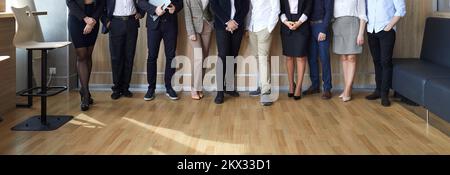 Banner image of legs of different business people standing in row in modern loft office. Stock Photo