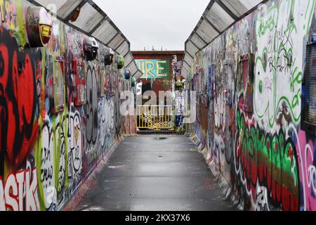 Graffiti painted  footbridge leading from Cheshire Street to Pedley Street Arch tunnel over the railway line in Shoreditch, London Stock Photo