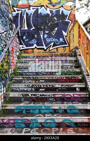 Graffiti painted steps on footbridge leading from Cheshire Street to Pedley Street Arch tunnel over the railway line in Shoreditch, London Stock Photo