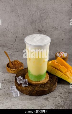 Boba or tapioca pearls is taiwan bubble milk tea in plastic cup with mango sticky rice flavor on texture  background, summers refreshment. Stock Photo