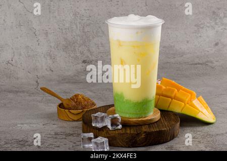 Boba or tapioca pearls is taiwan bubble milk tea in plastic cup with mango sticky rice flavor on texture  background, summers refreshment. Stock Photo