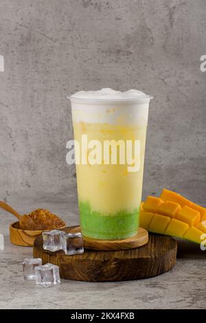 Boba or tapioca pearls is taiwan bubble milk tea in plastic cup with mango sticky rice flavor on texture  background, summers refreshment. Stock Photo
