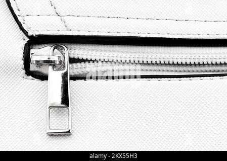 Zip closure on a white leather bag. Texture with a lock with a zipper Stock Photo
