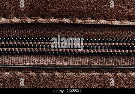 Zip closure on a brown leather bag. Texture with a lock with a zipper Stock Photo