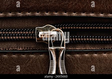 Zip closure on a brown leather bag. Texture with a lock with a zipper Stock Photo