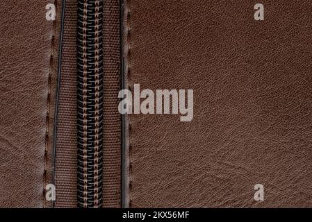 Zip closure on a brown leather bag. Texture with a lock with a zipper Stock Photo