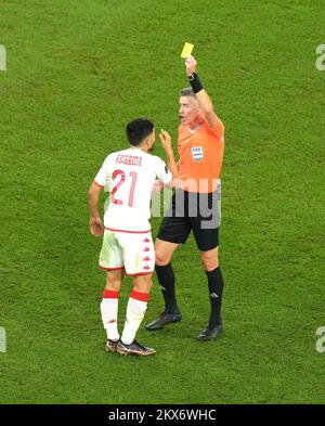 Referee Matthew Conger shows a yellow card to Tunisia's Wajdi Kechrida for a foul on France's Eduardo Camavinga (not pictured) during the FIFA World Cup Group D match at the Education City Stadium in Al Rayyan, Qatar. Picture date: Wednesday November 30, 2022. Stock Photo