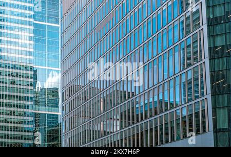 Detail of exteriors of high-rise buildings in Canary Wharf, covered with glass and windows, East London, UK Stock Photo