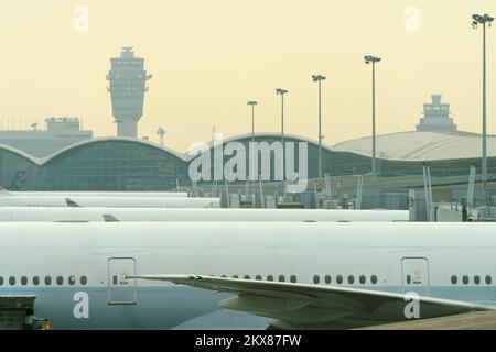 HONG KONG - MARCH, 09, 2015: Cathay Pacific aircraft near boarding bridge. Cathay Pacific is the flag carrier of Hong Kong, with its head office and m Stock Photo