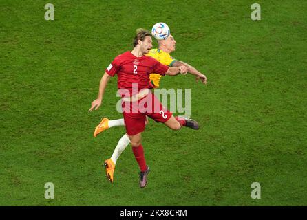 Denmark's Joachim Andersen (front) and Australia's Mitchell Duke battle for the ball during the FIFA World Cup Group D match at the Al Janoub Stadium in Al Wakrah, Qatar. Picture date: Wednesday November 30, 2022. Stock Photo