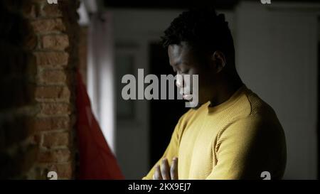 Pensive black African man standing by window, close-up face thinking2 Stock Photo