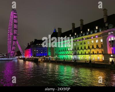 Westminster, London, UK. 29th November, 2022. Colourful lights on Westminster Bridge and the London Eye reflect onto the River Thames. Credit: Maureen McLean/Alamy Stock Photo