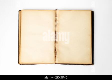Empty yellowed pages in a opened vintage book, isolated on white background, close up Stock Photo
