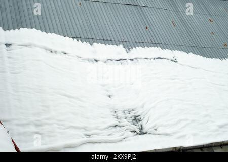 snow melting on a metal roof, accident hazard Stock Photo
