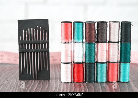 Colored needles and thread reel on patterned fabric placed on the left  side, copy space, white background, top view, sewing and embroidery concept  Stock Photo - Alamy