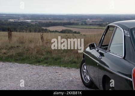 Old MG B GT parked up in lovely English countryside, looking off into the distance Stock Photo