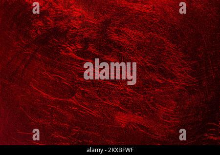 Shimmering metallic plastic film, and dark red background, with random structured surface. Stock Photo
