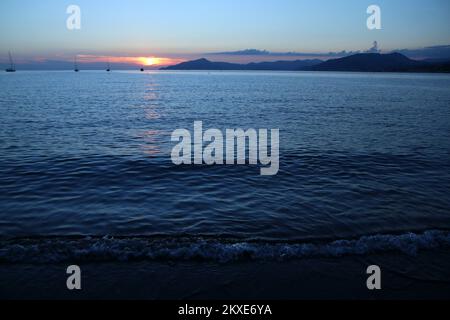 The detail of the calm surface of the sea with the small waves during the evening while sun went already down and the blue shades came. Stock Photo