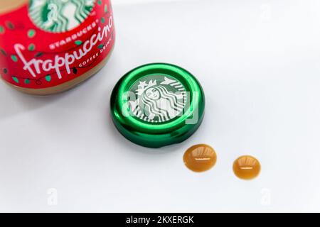London. UK. 11.30.2022. A close of a opened bottle of  Starbuck Frappuccino coffee with the company trademark, logo on the bottle cap isolated in a wh Stock Photo