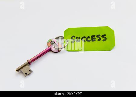 A key to success concept with a key and the word success isolated in white background. Stock Photo