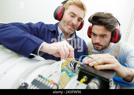 two technicians working on a machine Stock Photo