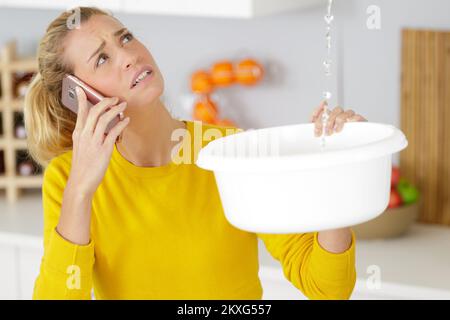 woman calling insurance for home leaks Stock Photo