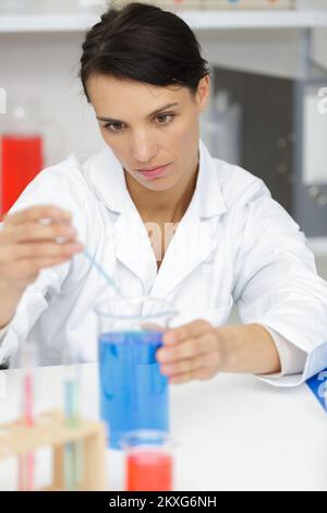 chemist woman mixing blue solution Stock Photo