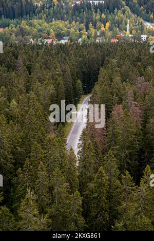 Empty road passing through the dense forest in autumn. Hidden road. finland Stock Photo