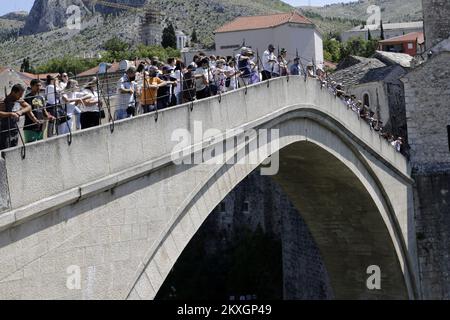 People watch a jump from the Old Bridge in Mostar, Bosnia and Herzegovina, on July 11, 20202. The jump without applause from the Old Bridge, organized by the Mostar River Jumper Club, is traditionally performed every year in memory of the victims of genocide in Srebrenica. Photo: Denis Kapetanovic/PIXSELL Stock Photo